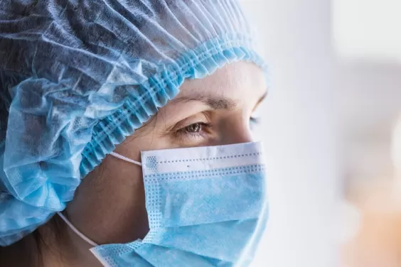 Female doctor in a medical mask and a protective cap