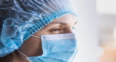 Female doctor in a medical mask and a protective cap